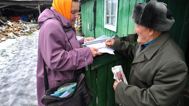 Житель деревни Татарская Караболка Кунашакского района Челябинской области расписывается за полученное ежемесячное денежное пособие. Архивное фото Житель деревни Татарская Караболка Кунашакского района Челябинской области расписывается за полученное ежемесячное денежное пособие. Архивное фото