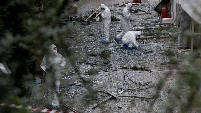 Сотрудники спецслужб на месте взрыва у здания телеканала в Афинах Сотрудники спецслужб на месте взрыва у здания телеканала в Афинах
