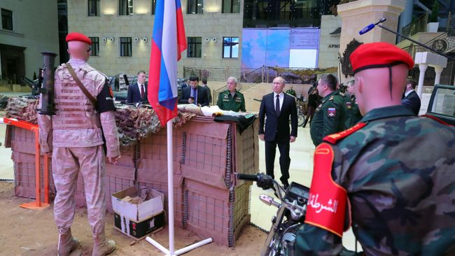 Владимир Путин во время осмотра выставки перед расширенным заседанием коллегии министерства обороны РФ. 18 декабря 2018