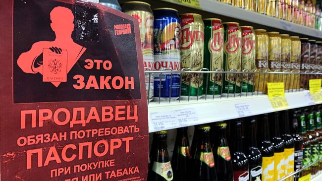 Листовка с надписью Продавец обязан потребовать паспорт при покупке алкоголя или табака на полке с алкогольными напитками в магазине Листовка с надписью Продавец обязан потребовать паспорт при покупке алкоголя или табака на полке с алкогольными напитками в магазине