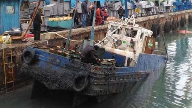 Затонувший буксир РБТ-18 поднят со дна портальным краном в Керченском торговом порту. 30 декабря 2018 Затонувший буксир РБТ-18 поднят со дна портальным краном в Керченском торговом порту. 30 декабря 2018
