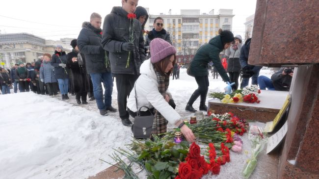 Местные жители возлагают цветы к памятнику Орлёнок в Челябинске на акции памяти по погибшим при обрушении одного из подъездов дома в Магнитогорске. 3 января 2019