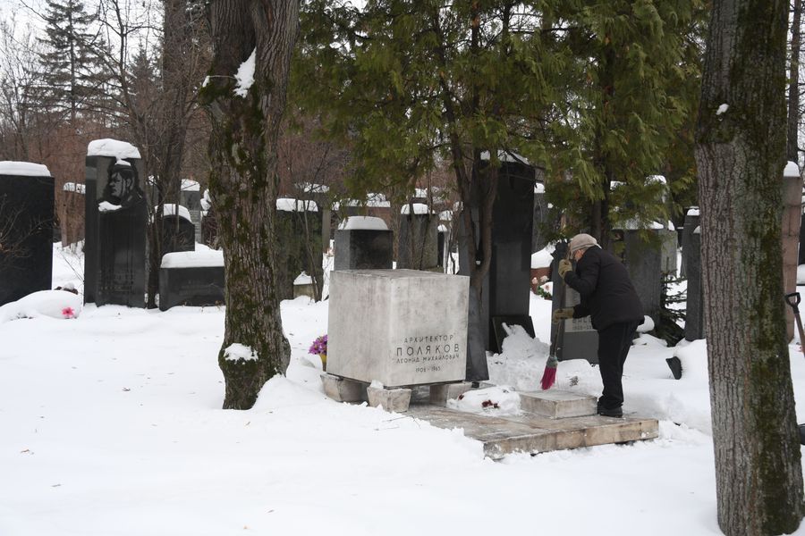 Женщина очищает от снега могилу архитектора Леонида Полякова Женщина очищает от снега могилу архитектора Леонида Полякова