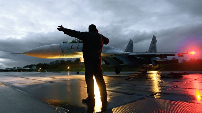 Военный техник дает отмашку на взлет истребителя Су-27 на аэродроме Чкаловск в Калининградской области Военный техник дает отмашку на взлет истребителя Су-27 на аэродроме Чкаловск в Калининградской области