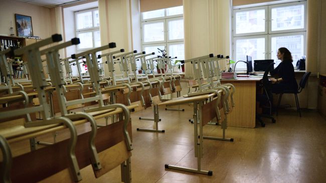 Преподаватель в пустом учебном классе школы. Архивное фото Преподаватель в пустом учебном классе школы. Архивное фото