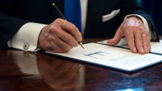 Президент США Дональд Трамп подписывает документ в Овальном кабинете Белого дома Президент США Дональд Трамп подписывает документ в Овальном кабинете Белого дома
