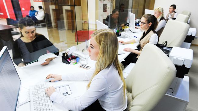 Женщина оформляет документы в одном из МФЦ