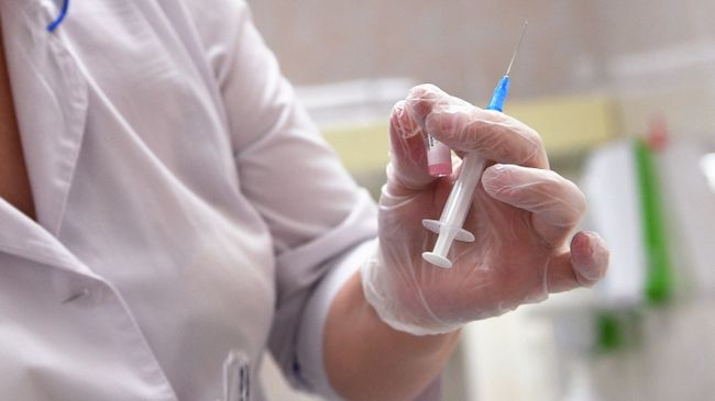 Медицинская сестра готовит шприц для прививки от кори Медицинская сестра готовит шприц для прививки от кори