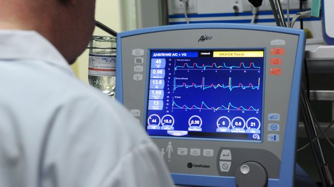 Врач корректирует параметры искусственной вентиляции легких на аппарате в отделении реанимации и интенсивной терапии