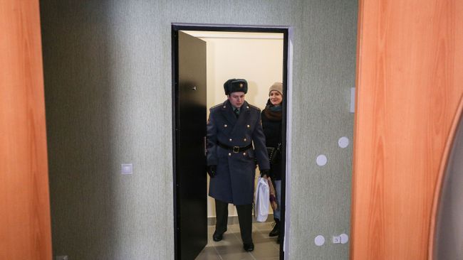 Новоселы заходят в свою новую квартиру после церемонии торжественной передачи служебного жилья военнослужащим войсковой части