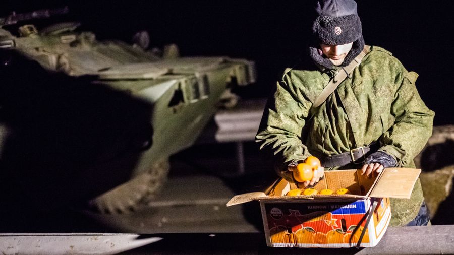 Военнослужащий с ящиком мандаринов на блокпосту на въезде в Крым в районе Армянска Военнослужащий с ящиком мандаринов на блокпосту на въезде в Крым в районе Армянска