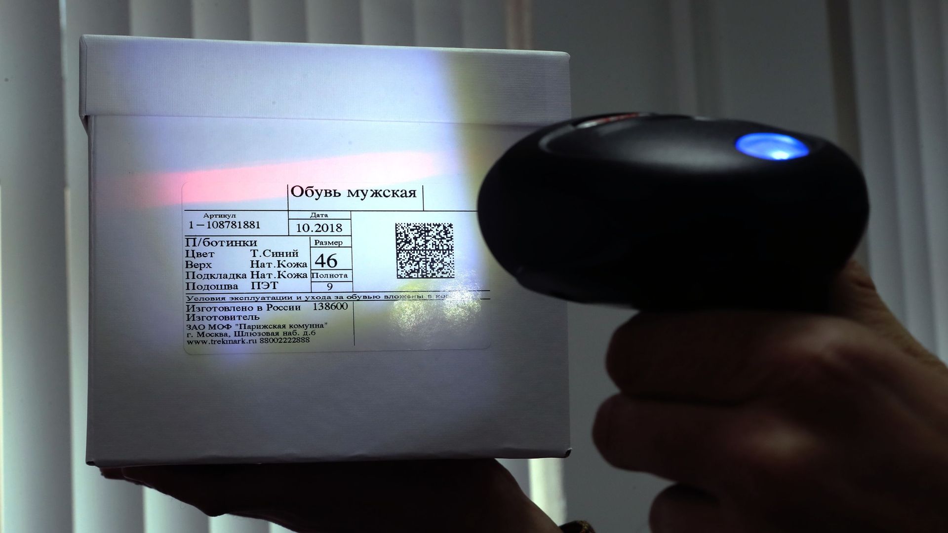 Сканер штрих-кода считывает этикетку с QR-кодом с коробки с обувью Сканер штрих-кода считывает этикетку с QR-кодом с коробки с обувью - РИА Новости, 1920, 24.12.2022