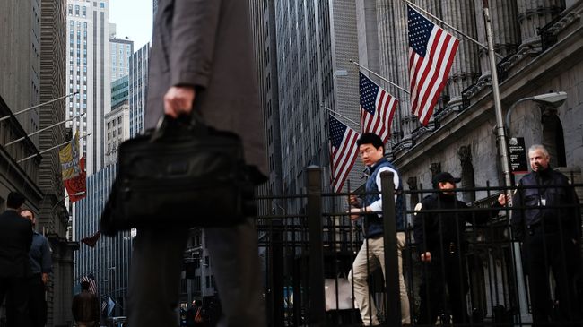 Прохожие на улице Уолл-Стрит в Нью-Йорке, США Прохожие на улице Уолл-Стрит в Нью-Йорке, США