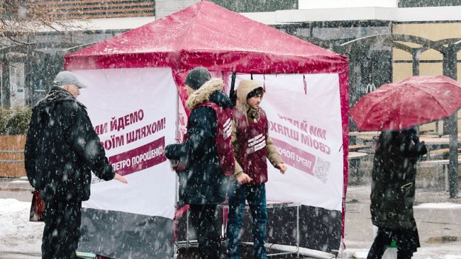 Прохожие и волонтеры у агитационной палатки с печатной продукцией кандидата и действующего президента Украины Петра Порошенко Прохожие и волонтеры у агитационной палатки с печатной продукцией кандидата и действующего президента Украины Петра Порошенко