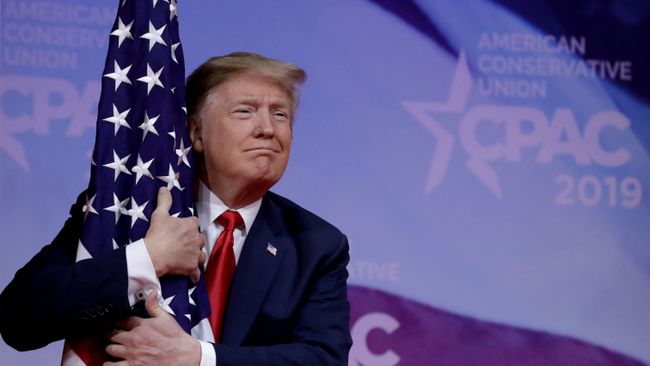 Президент США Дональд Трамп обнимает американский флаг Президент США Дональд Трамп обнимает американский флаг
