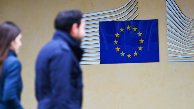 Прохожие у здания Европейской комиссии в Брюсселе Прохожие у здания Европейской комиссии в Брюсселе