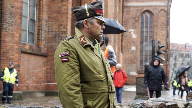 Участник перед началом марша легионеров Waffen SS у церкви Святого Петра в Риге. 16 марта 2019