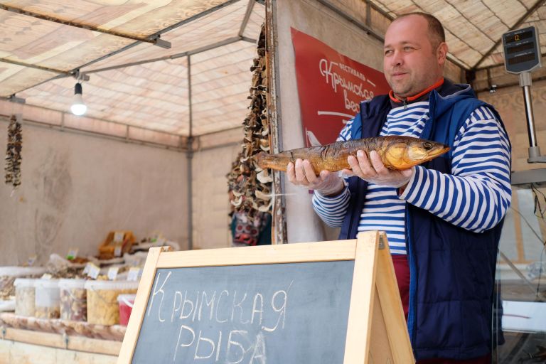 Продавец демонстрирует рыбу для продажи на ярмарке в рамках фестиваля Крымская весна в Краснодаре Продавец демонстрирует рыбу для продажи на ярмарке в рамках фестиваля Крымская весна в Краснодаре