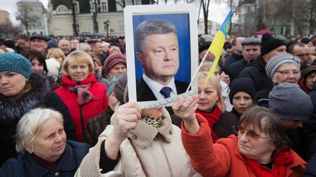 Люди слушают предвыборную речь президента Украины Петра Порошенко на Михайловской площади в Киеве Люди слушают предвыборную речь президента Украины Петра Порошенко на Михайловской площади в Киеве