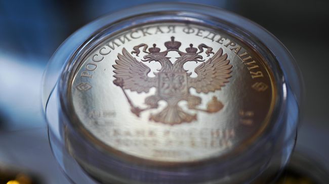 Герб РФ на монете. Архивное фото Герб РФ на монете. Архивное фото