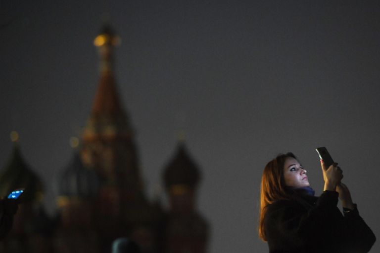 Девушка на Красной площади в Москве во время отключения подсветки в рамках экологической акции Час Земли Девушка на Красной площади в Москве во время отключения подсветки в рамках экологической акции Час Земли