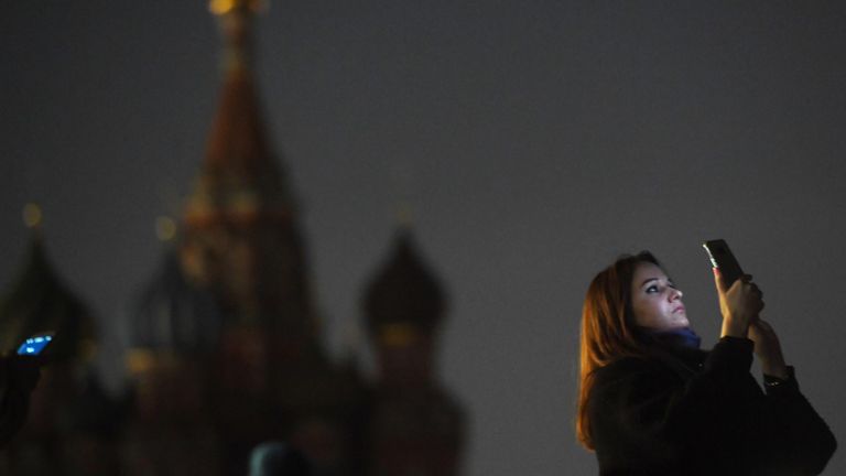 Девушка на Красной площади в Москве во время отключения подсветки в рамках экологической акции Час Земли Девушка на Красной площади в Москве во время отключения подсветки в рамках экологической акции Час Земли