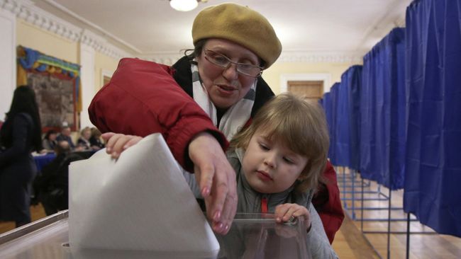 Женщина голосует на избирательном участке во время президентских выборов в Киеве, Украине Женщина голосует на избирательном участке во время президентских выборов в Киеве, Украине