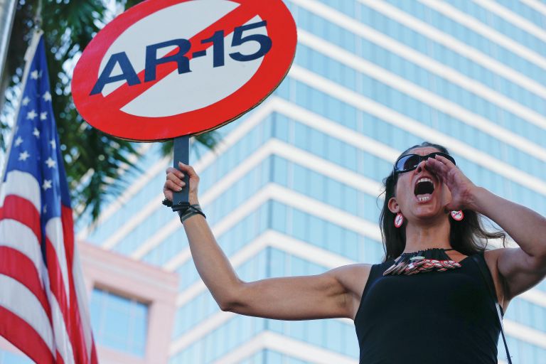Девушка с плакатом против использования винтовки AR-15 во время акции протеста против ношения оружия в США Девушка с плакатом против использования винтовки AR-15 во время акции протеста против ношения оружия в США