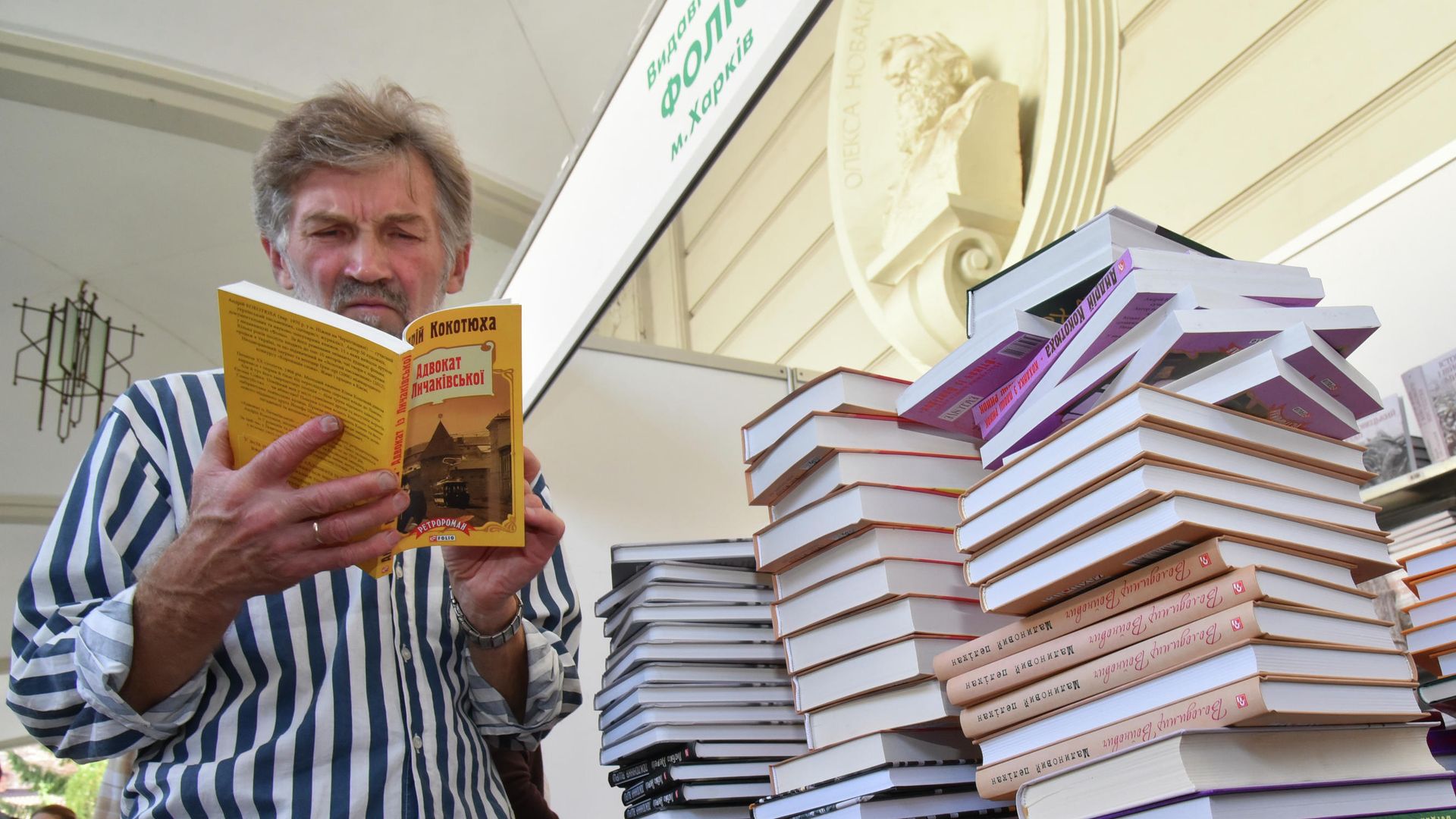 Посетитель читает книгу на книжной ярмарке во Львове Посетитель читает книгу на книжной ярмарке во Львове - РИА Новости, 1920, 07.11.2021