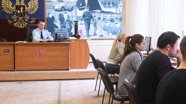 Люди сдают теоретические экзамены по правилам дорожного движения в отделении ГИБДД в Москве Люди сдают теоретические экзамены по правилам дорожного движения в отделении ГИБДД в Москве