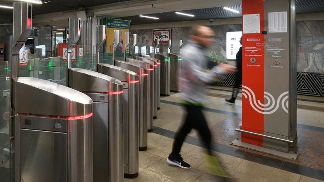 Пассажир московского метро проходит через турникеты на станции Октябрьское Поле Пассажир московского метро проходит через турникеты на станции Октябрьское Поле