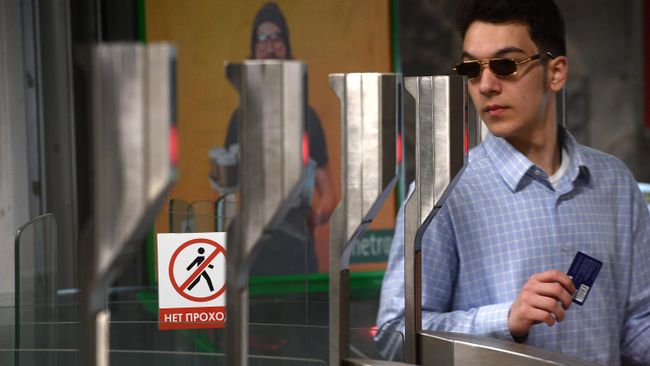 Пассажир московского метро проходит через турникет на станции Октябрьское Поле