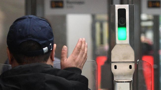 Пассажир московского метро проходит через турникеты на станции Октябрьское Поле Пассажир московского метро проходит через турникеты на станции Октябрьское Поле