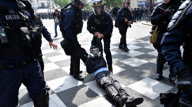 Полицейские задерживают демонстранта на первомайской демонстрации в Париже. 1 мая 2019 Полицейские задерживают демонстранта на первомайской демонстрации в Париже. 1 мая 2019