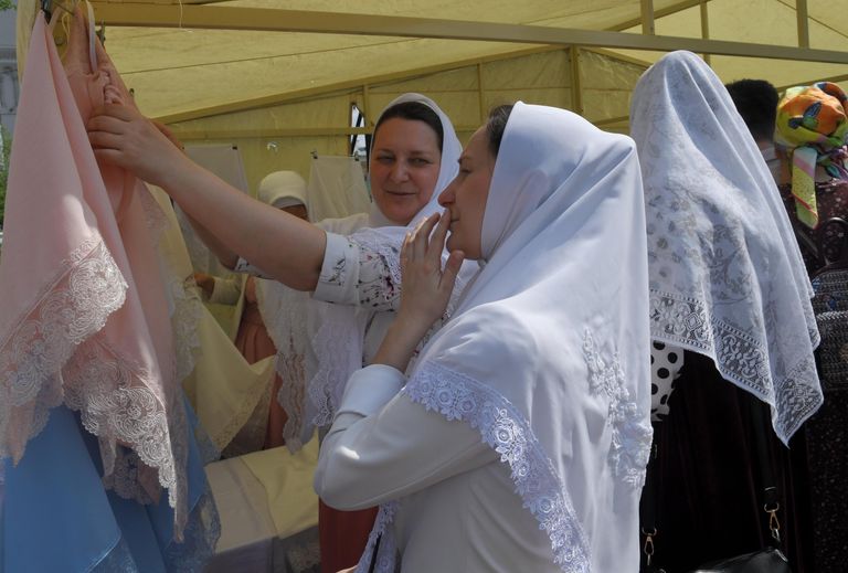 Женщина выбирает платок в день праздника Святых Жён-Мироносиц в духовном центре старообрядчества Рогожская слобода в Москве Женщина выбирает платок в день праздника Святых Жён-Мироносиц в духовном центре старообрядчества Рогожская слобода в Москве
