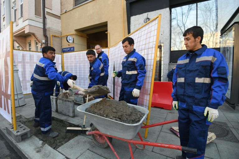 Рабочие укладывают тротуарную плитку на Никитском бульваре в Москве