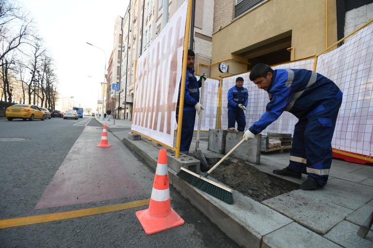 Рабочие укладывают тротуарную плитку на Никитском бульваре в Москве