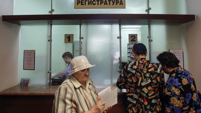 Пациенты у окон регистратуры в поликлинике Пациенты у окон регистратуры в поликлинике