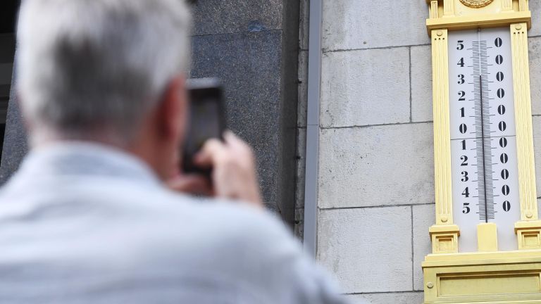 Мужчина фотографирует термометр на здании Государственной Думы РФ в Москве