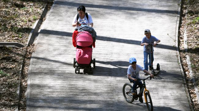 Женщина гуляет с детьми в парке Женщина гуляет с детьми в парке