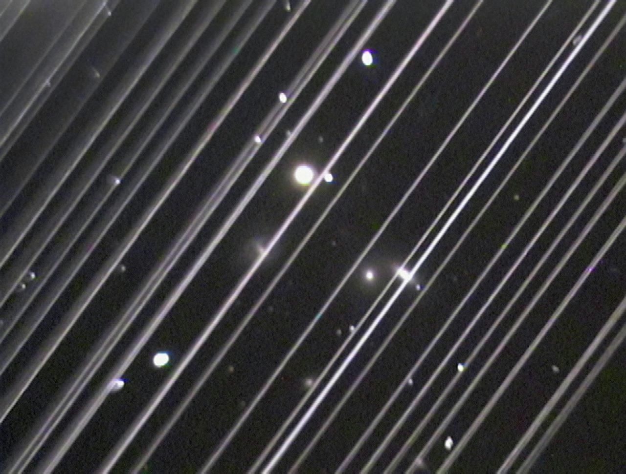Фотография группы галактик NGC 5353/4 в созвездии Гончих Псов. Светлые линии на снимке – спутники системы Starlink Фотография группы галактик NGC 5353/4 в созвездии Гончих Псов. Светлые линии на снимке – спутники системы Starlink - РИА Новости, 1920, 14.06.2024