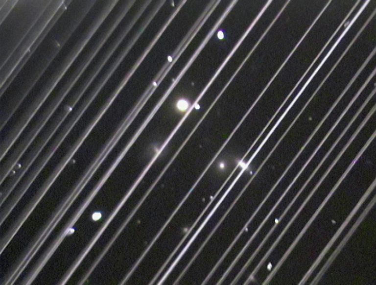 Фотография группы галактик NGC 5353/4 в созвездии Гончих Псов. Светлые линии на снимке – спутники системы Starlink Фотография группы галактик NGC 5353/4 в созвездии Гончих Псов. Светлые линии на снимке – спутники системы Starlink