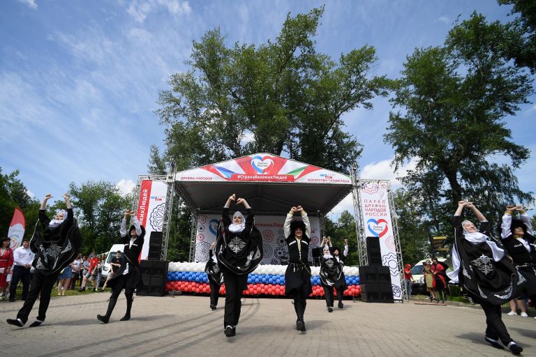 Молодые люди в национальных костюмах выступают на праздновании Дня России в парке им. М. Горького в Казани Молодые люди в национальных костюмах выступают на праздновании Дня России в парке им. М. Горького в Казани
