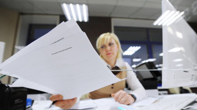 Специалист МФЦ выдает документы Специалист МФЦ выдает документы