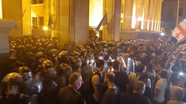 Сотрудники полиции и участники акции протеста у здания парламента Грузии в Тбилиси