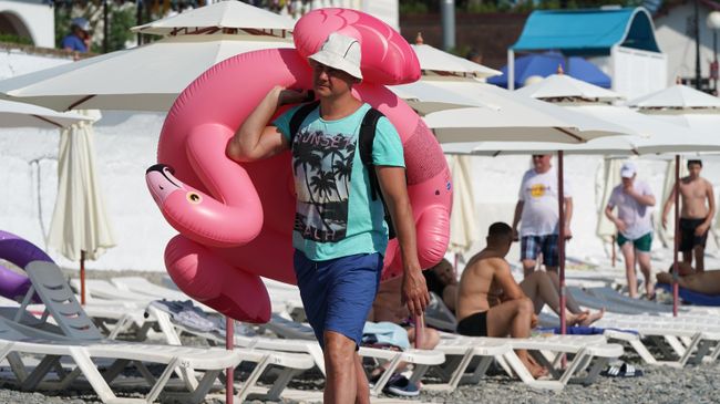 Мужчина с надувным кругом на пляже в районе Адлер города Сочи Мужчина с надувным кругом на пляже в районе Адлер города Сочи