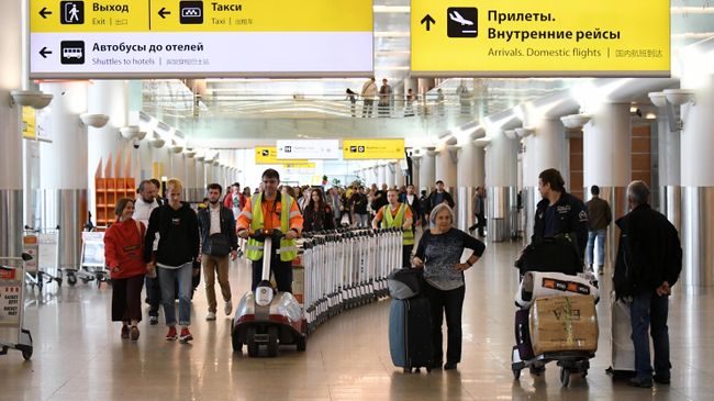 Пассажиры с чемоданами в аэропорту Шереметьево Пассажиры с чемоданами в аэропорту Шереметьево