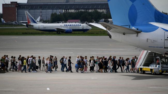 Пассажиры идут на посадку в самолет Boeing 737-800 авиакомпании Pobeda в аэропорту Внуково Пассажиры идут на посадку в самолет Boeing 737-800 авиакомпании Pobeda в аэропорту Внуково