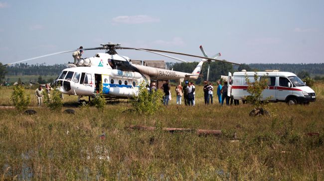 Вертолет Ми-8АМТ с медицинским модулем на борту и машина скорой помощи в Тулунском районе Иркутской области, где происходит ликвидация последствий паводка