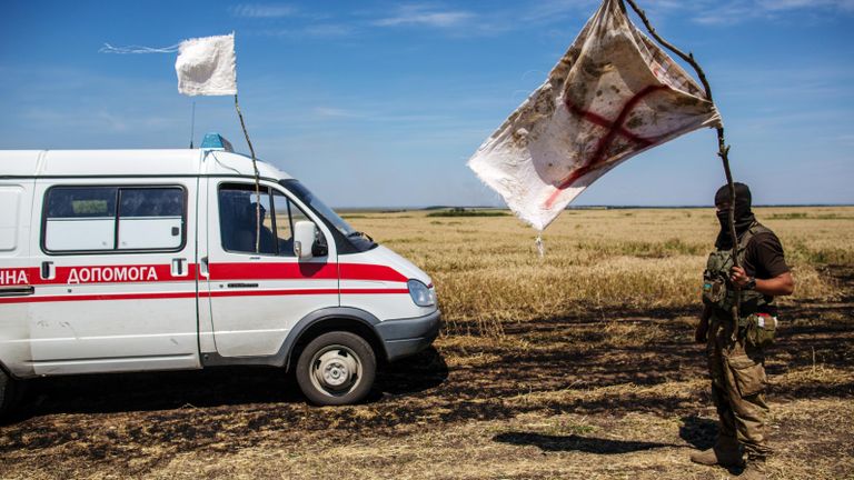 Украинский военный с белым флагом во время передачи убитых на нейтральной территории вблизи поселка Диброво возле российско-украинской границы в Донецкой области Украинский военный с белым флагом во время передачи убитых на нейтральной территории вблизи поселка Диброво возле российско-украинской границы в Донецкой области